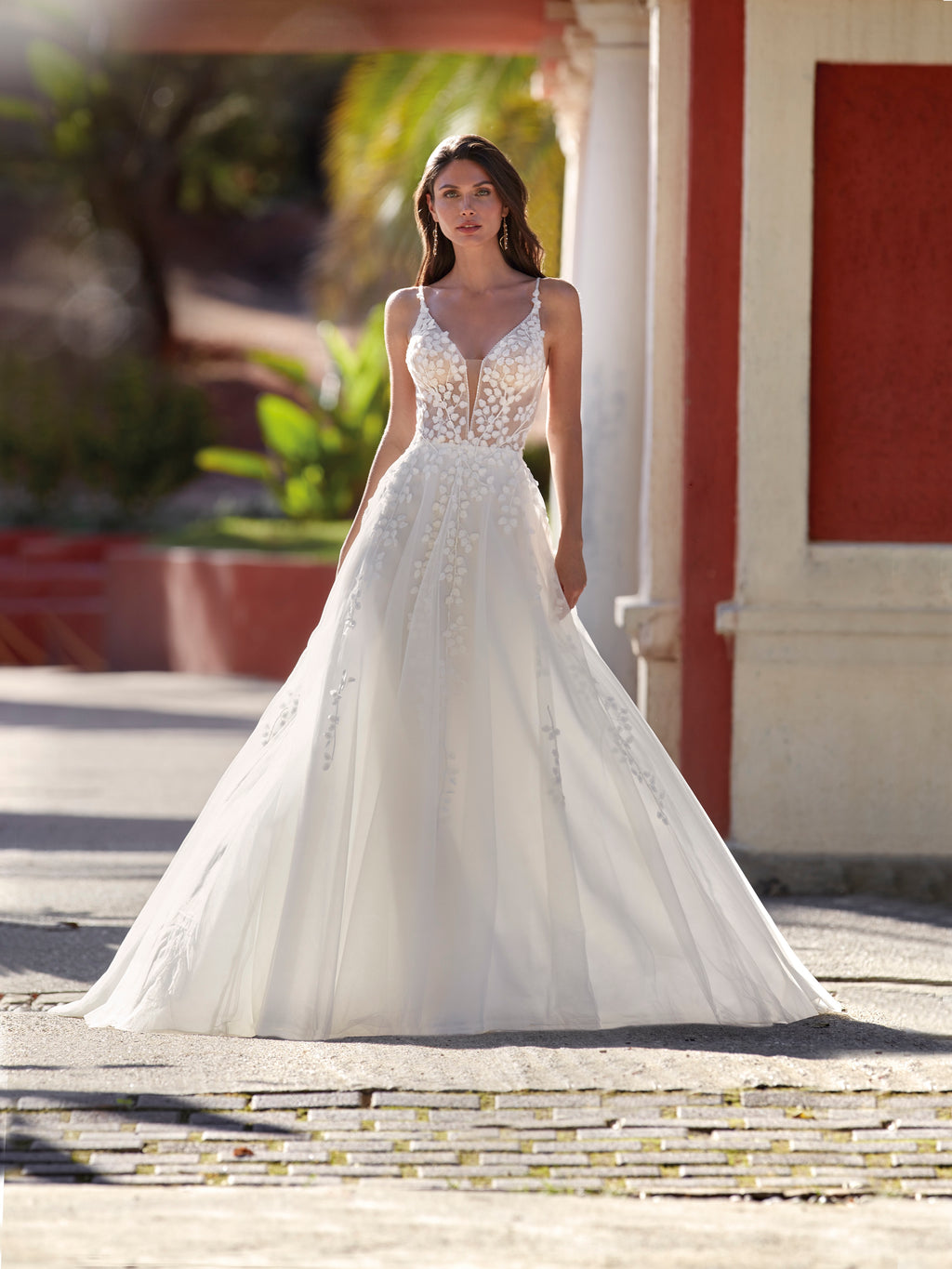 Woman in a white wedding dress standing outdoors with classical architecture in the background