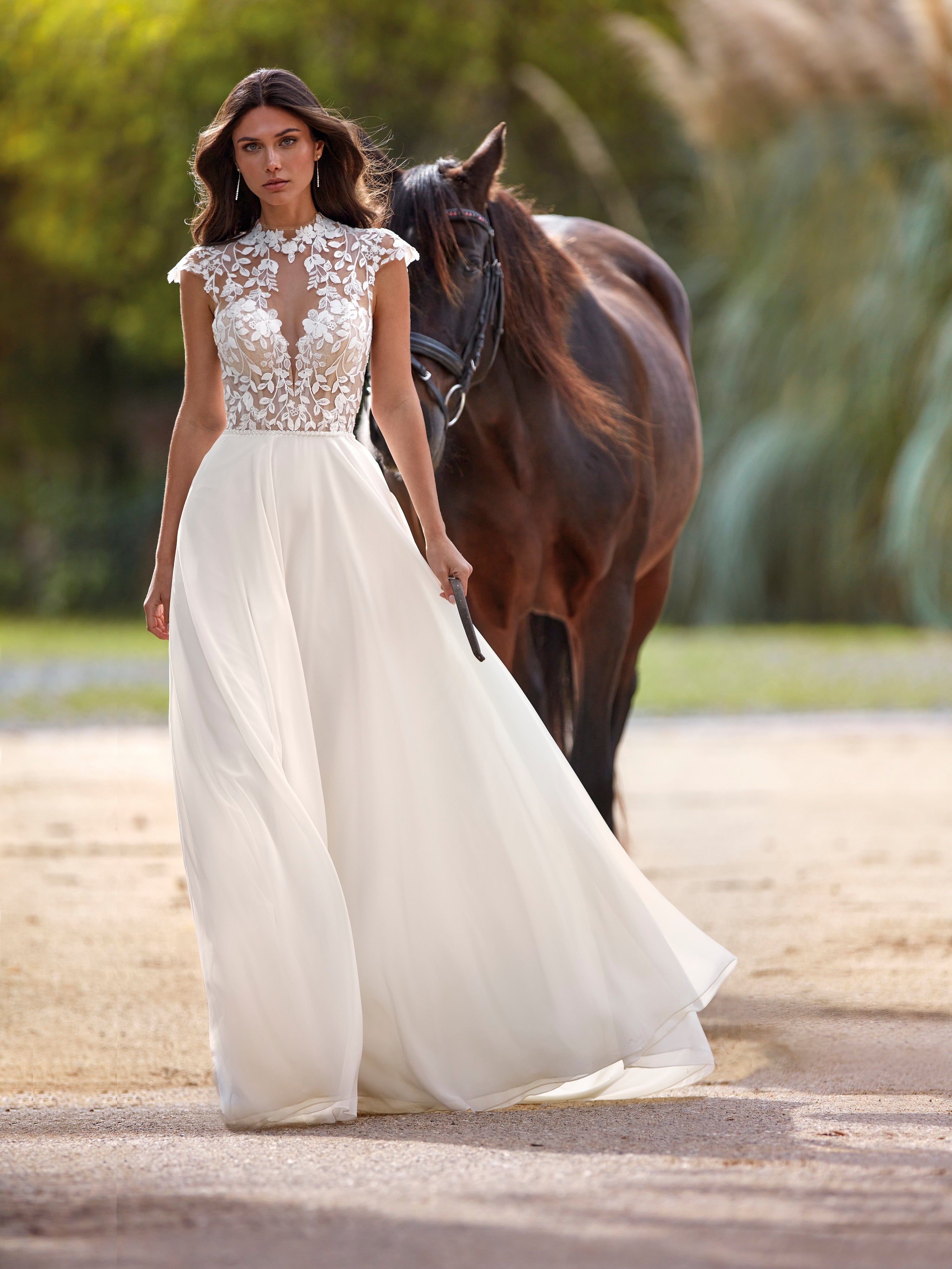 Woman in a white wedding dress with a horse in an outdoor setting