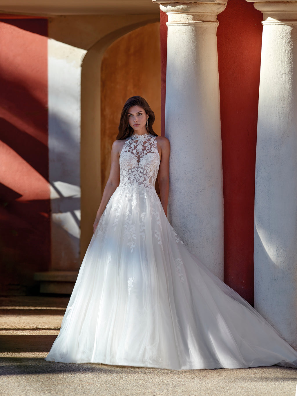 Woman in a white wedding dress standing in front of classical architecture.