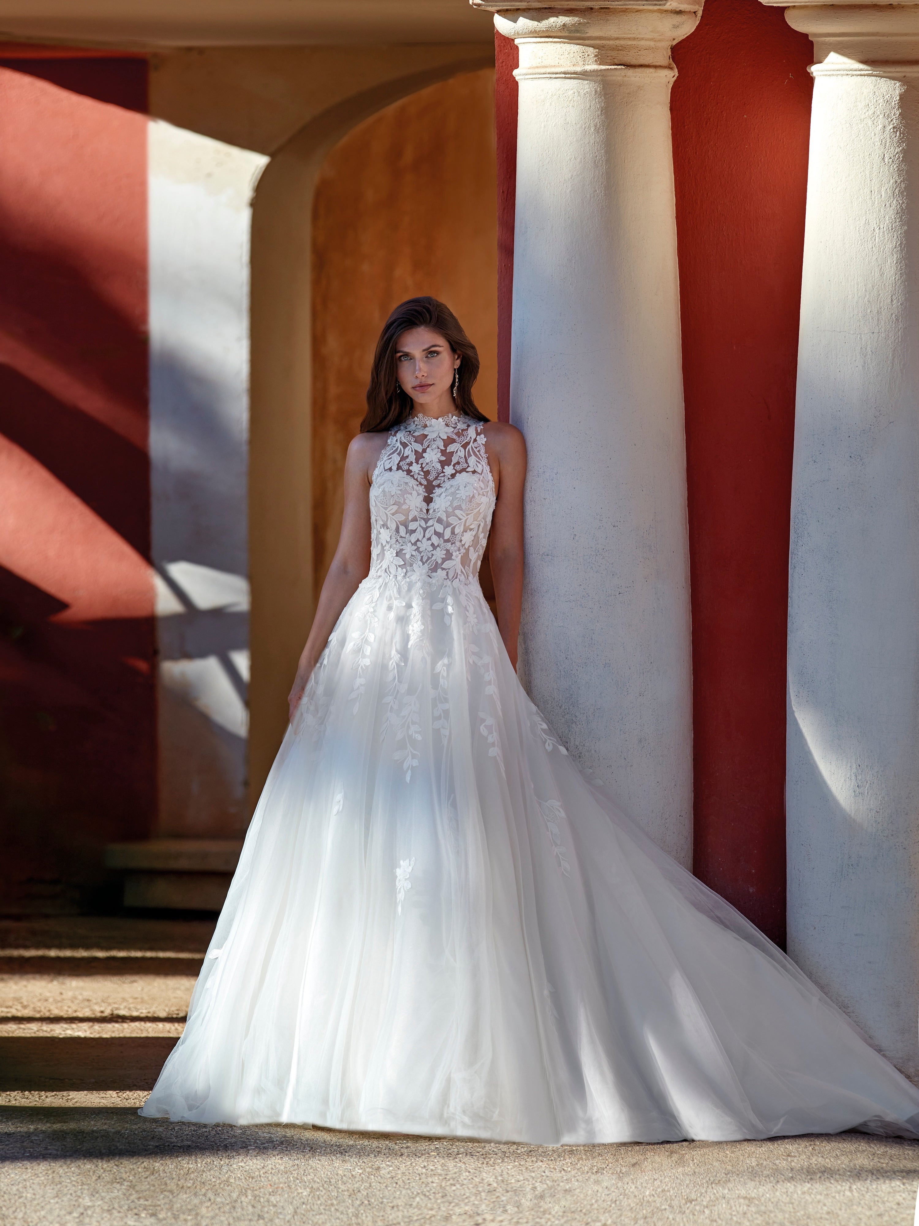 Woman in a white wedding dress standing in front of classical architecture.