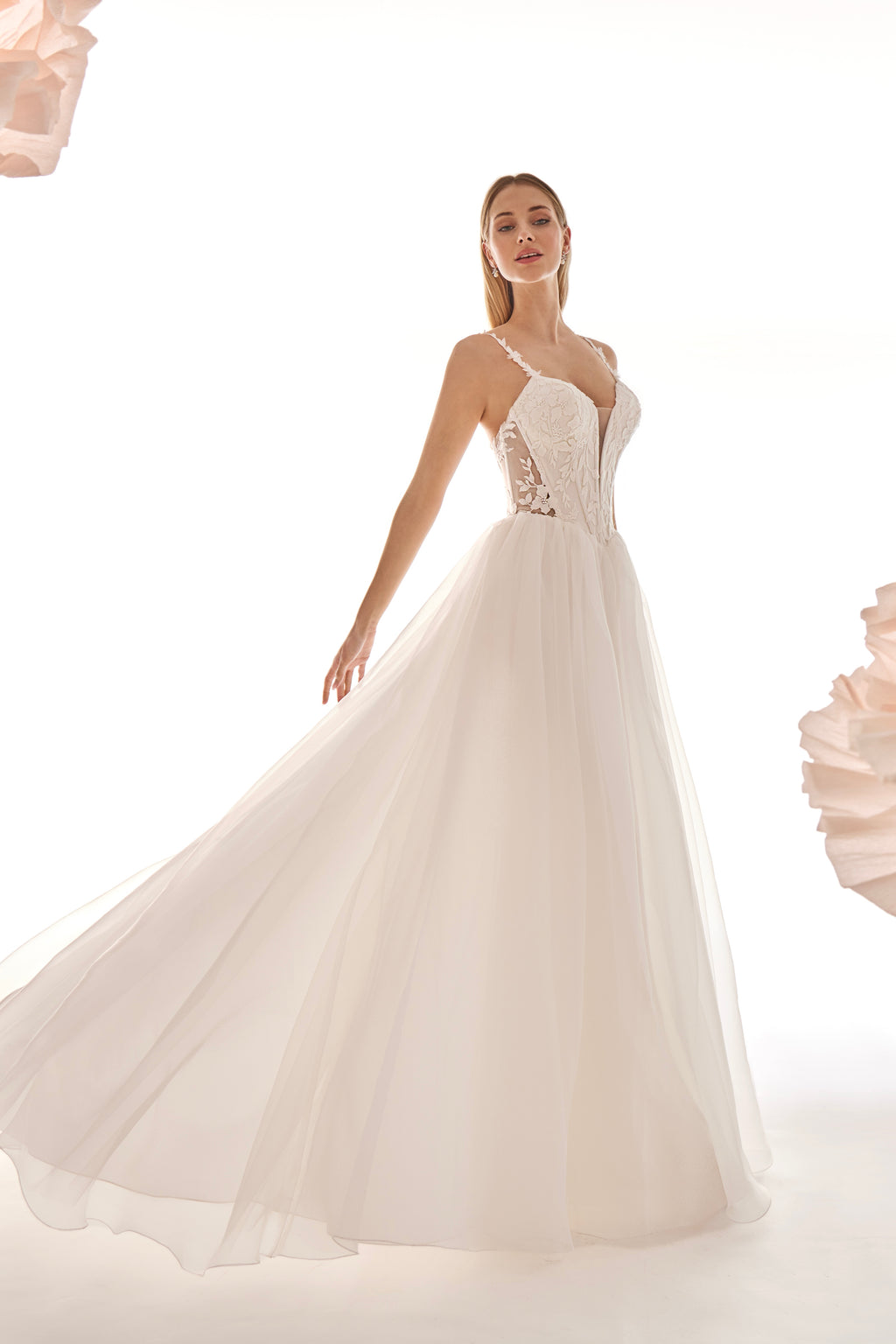 Woman wearing a white wedding dress with a floral headband and bouquet on a white background
