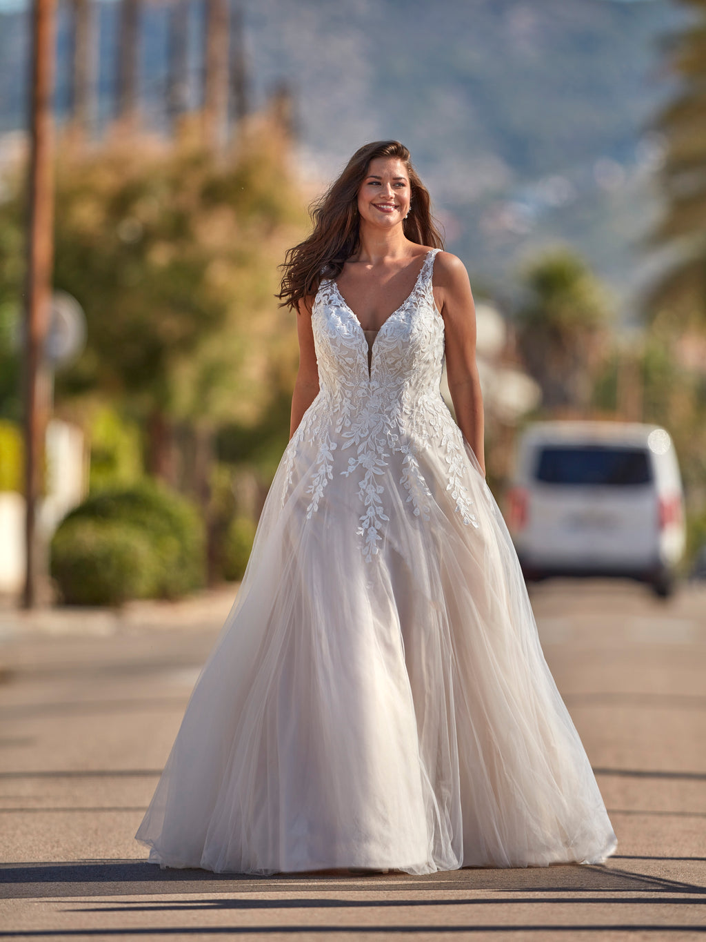 Woman in a white wedding dress standing on a street with blurred background