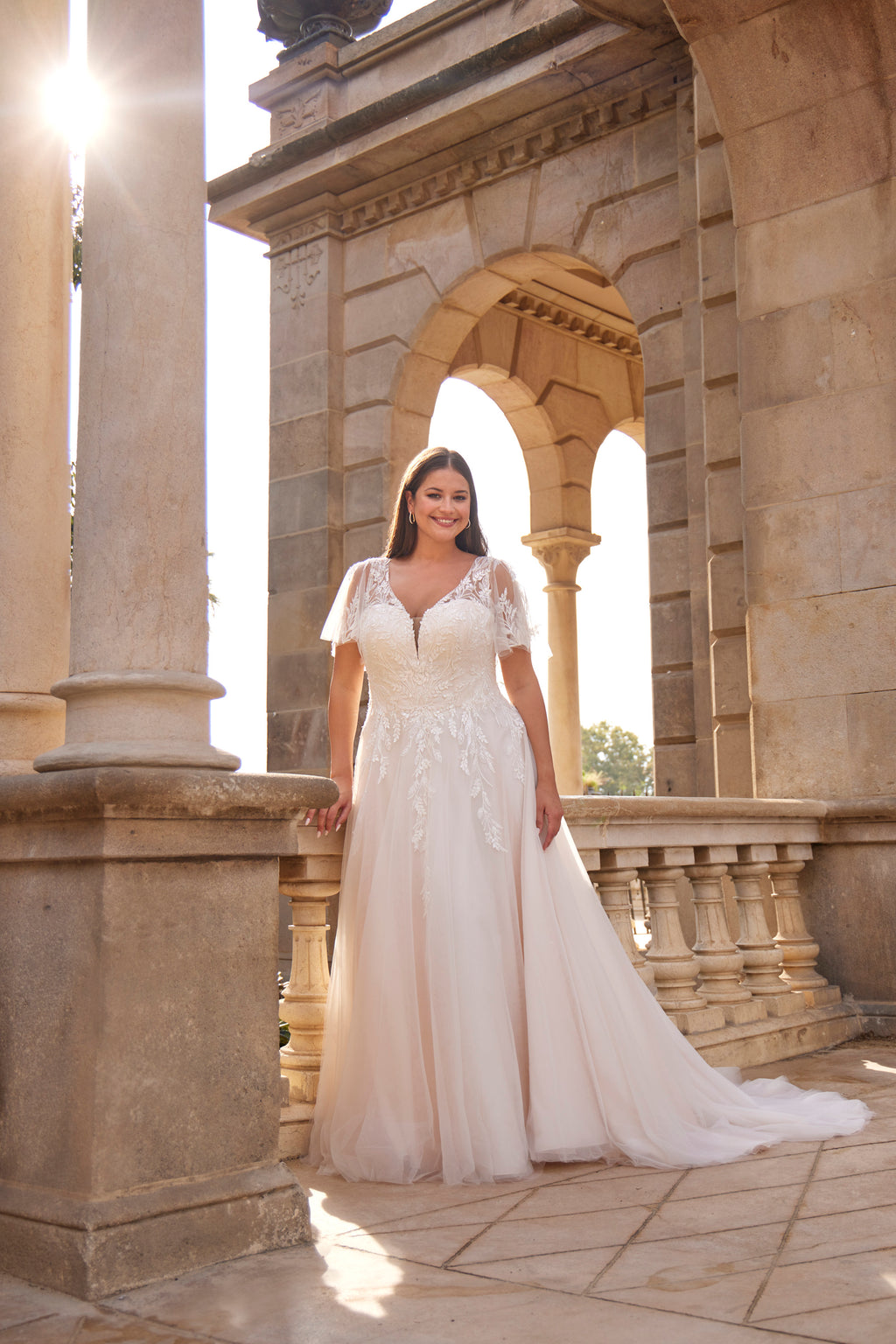Woman in a white wedding dress standing in front of classical architecture