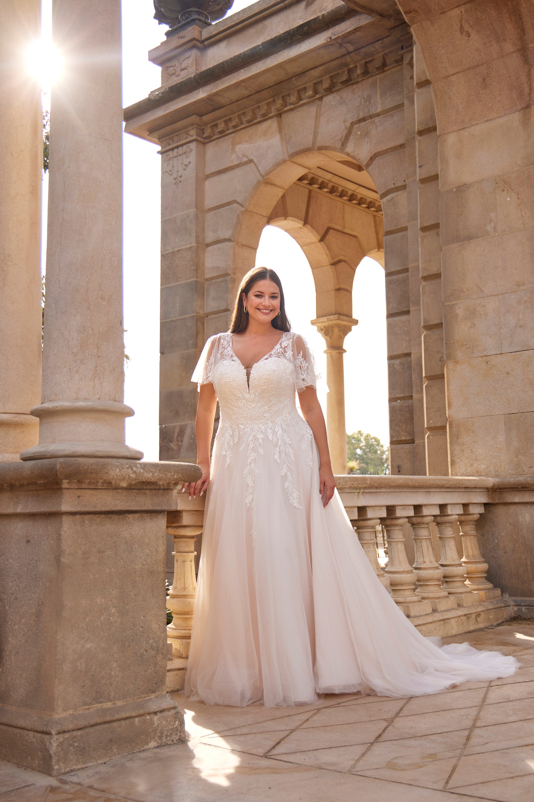 Woman in a white wedding dress standing in front of classical architecture