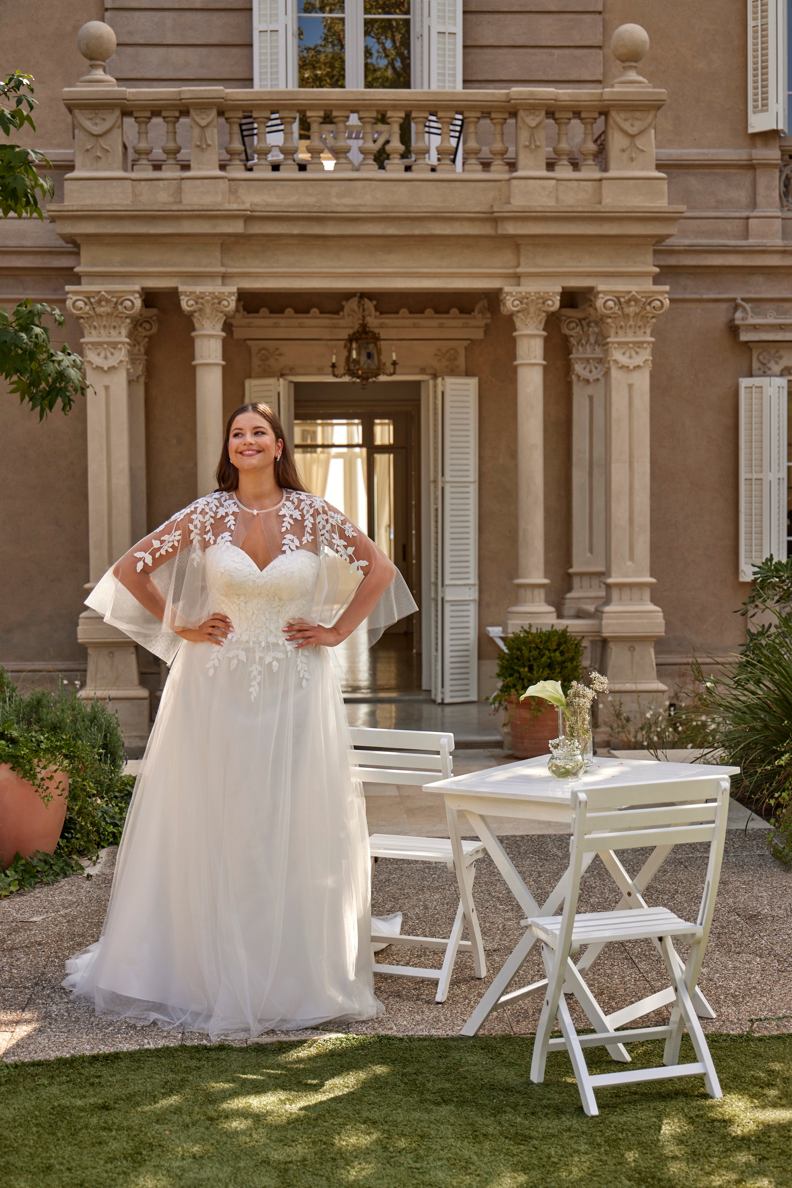 Woman in a white wedding dress standing in front of a classical building.