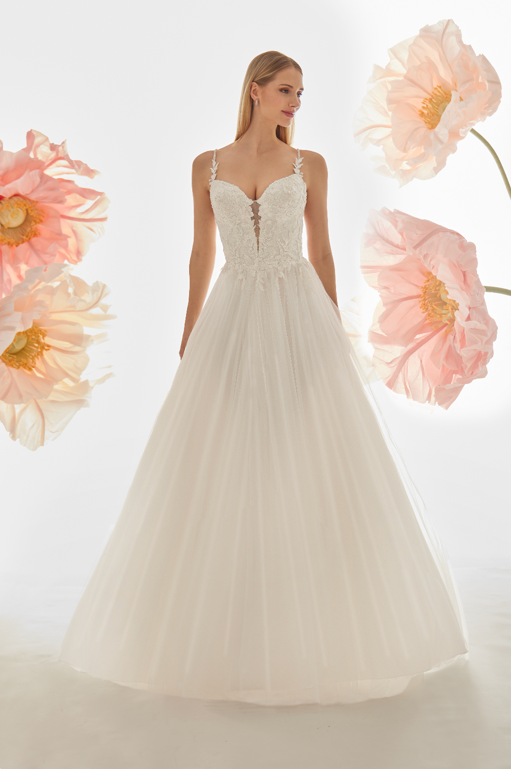 Woman wearing a white wedding dress with pink flowers in the background