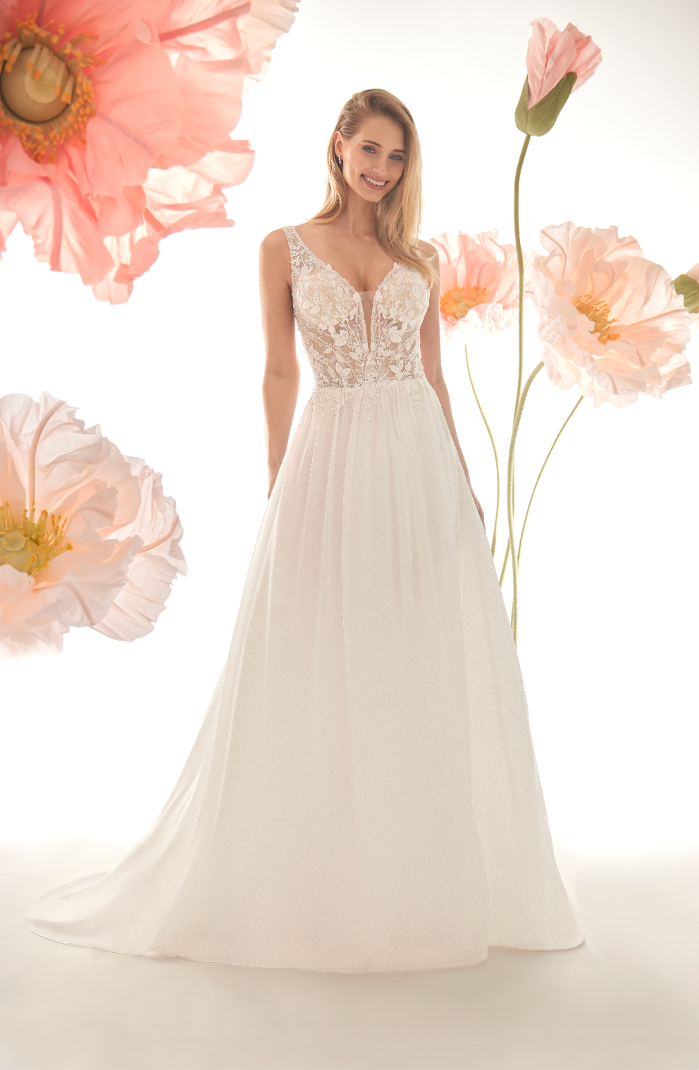 Woman in a white wedding dress standing among pink flowers on a white background