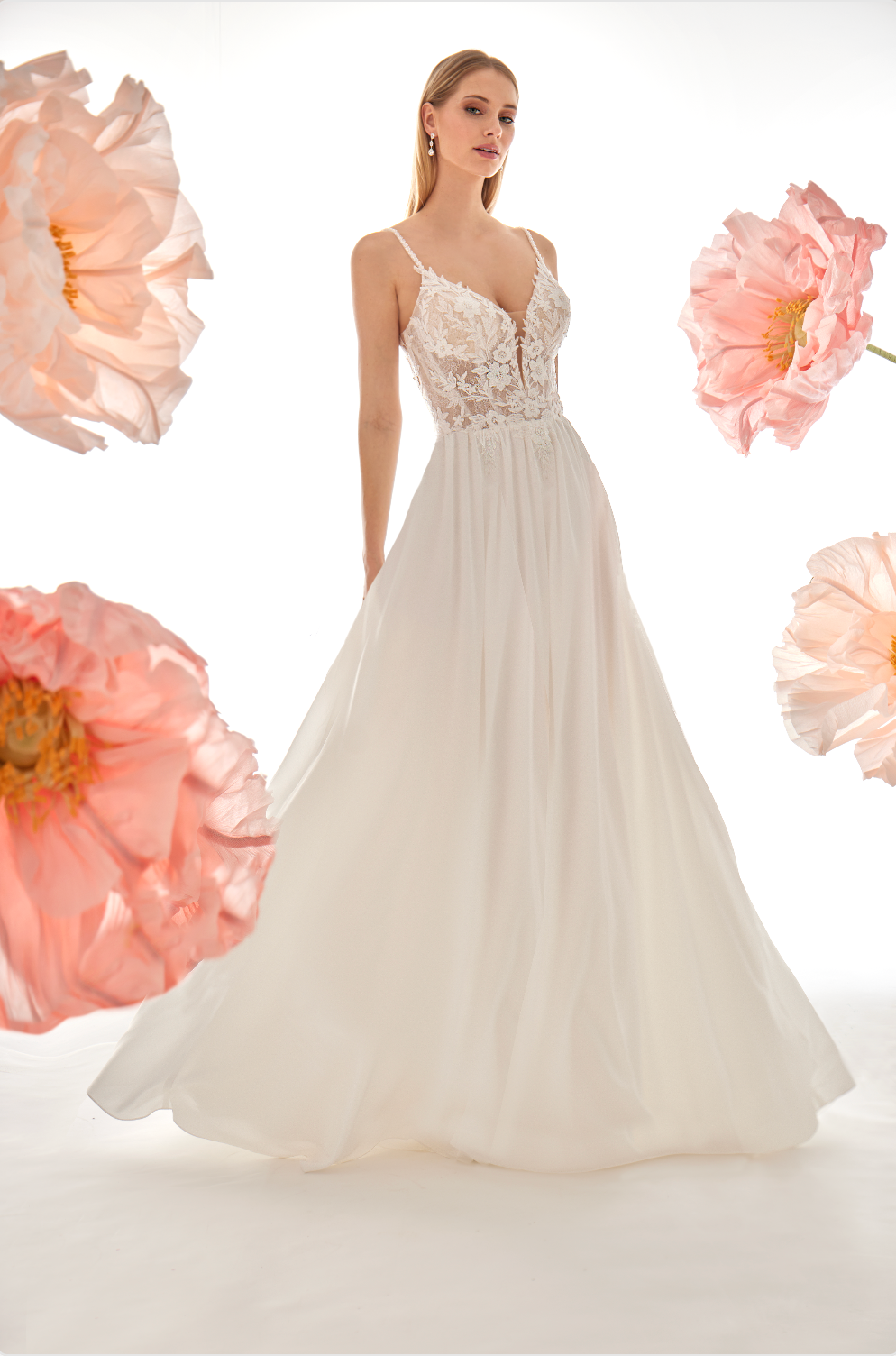 White wedding dress with floral details on a white background with pink flowers.